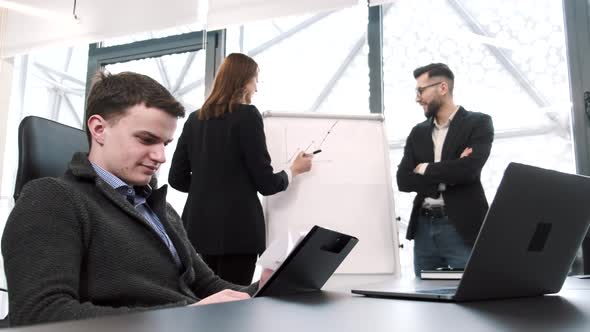 Three Coworkers Working on a Project at Office