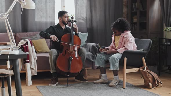 Girl Learning from Musician Playing Double Bass