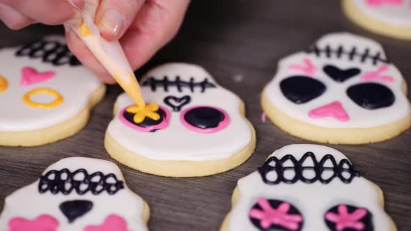 Step by step. Decorating sugar skull cookies with different color royal icing.