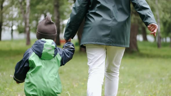 Funny Kid in Rain Boots Playing in a Rain Park