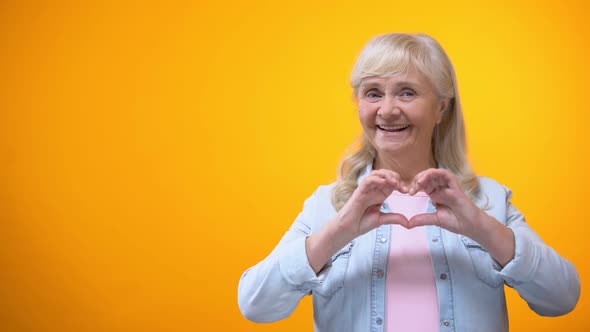 Happy Retiree Lady Showing Hand Heart Gesture