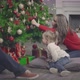 Young Parents and Little Daughter Decorating Christmas Tree Together - VideoHive Item for Sale