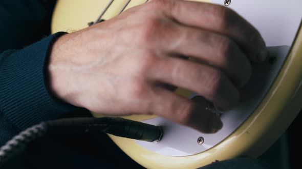 Musician Inserts Jack Into Output and Rotates Control Knobs