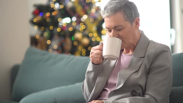 A Caring Husband Covers His Wife with a Blanket While She Sits on the Couch