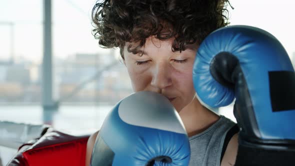 Closeup Portrait of Attractive Girl Wearing Boxing Gloves Looking at Camera in Gym