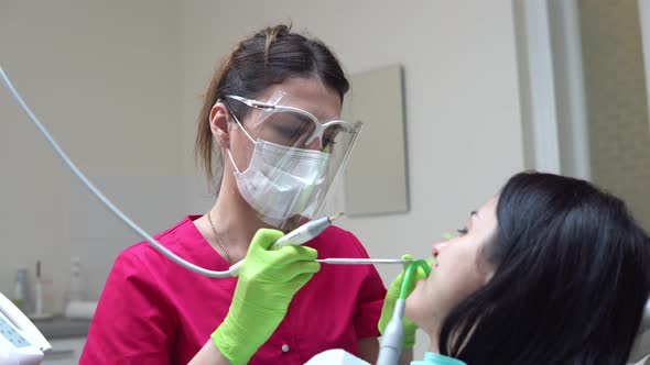 Woman at the Dental Hygienist Getting Professional Tooth Whitening and Ultrasound Cleaning