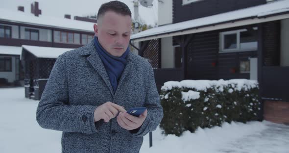 A Man Dials A Phone Number On His Mobile