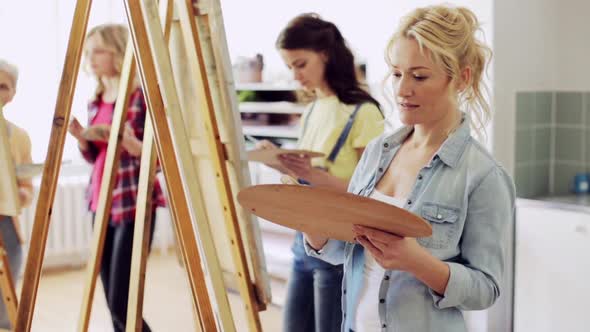 Students with Easels Painting at Art School 
