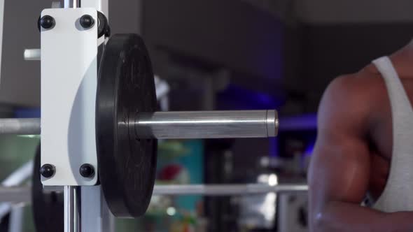 African Man Putting Weight Plates on Barbell, Exercising at the Gym