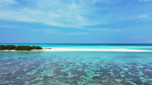 Wide angle aerial island view of a sunshine white sandy paradise beach and aqua turquoise water back