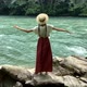 Young beautiful vintage woman in long skirt and straw hat dancing on stones near mountain river - VideoHive Item for Sale