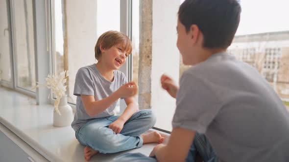 Friends Play to Rock Paper Scissors Game on Window Sill