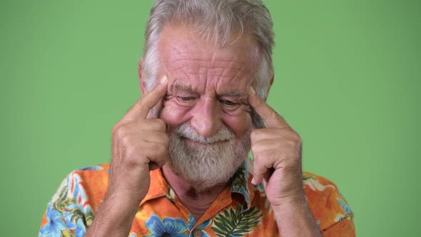 Handsome Senior Bearded Tourist Man Ready for Vacation Against Green Background