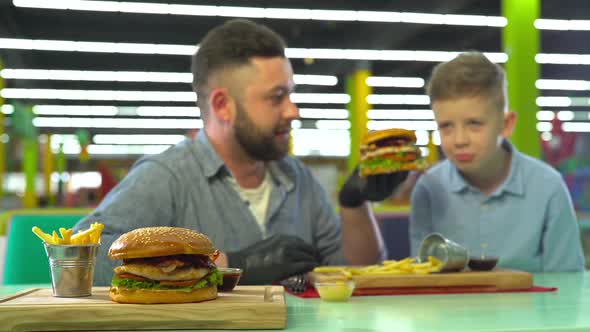 Slow Motion of Father and Son Eating Burger at Restaurant