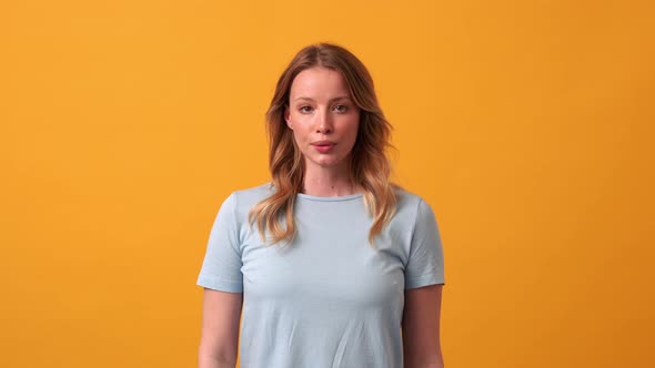 Confident blonde woman wearing blue t-shirt looking at the camera