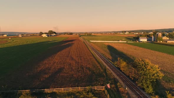 Drone View of Crops Waiting to be Harvested as a Stream Passenger Train Approaches During the Golden