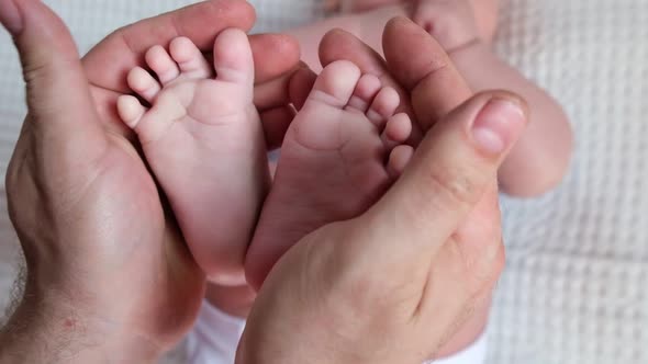 Father Holding Baby Feet in Hands