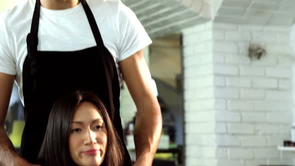 Male hairdresser styling a womans hair