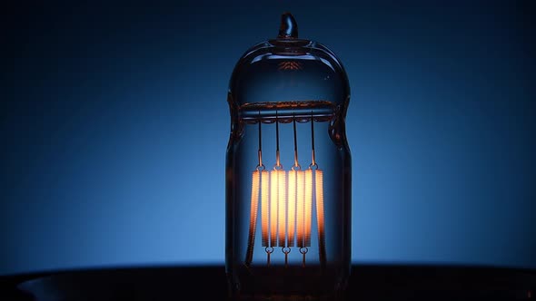 Electric Vintage Edison Light Bulb with a Spiral Flashing on a Blue Background