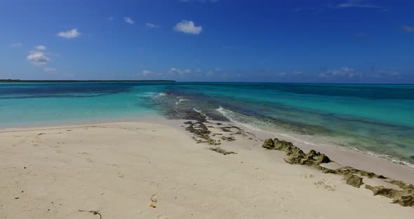 Natural drone tourism shot of a sunshine white sandy paradise beach and blue ocean background in hig