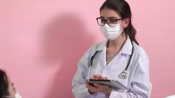 Doctor Wearing Face Mask Proficiently Talks with Patient at Hospital Ward