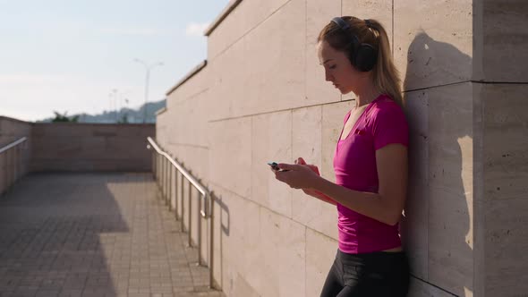 Fitness Girl Choosing Music to Train with