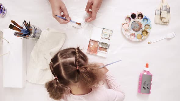 Mother and daughter painting with gold paint clay sculpted horn and ears for decorating craft pumpki