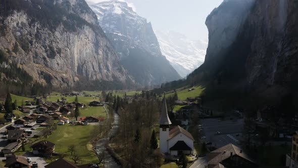 Aerial turns to the right and shows Lauterbrunnen town and the waterfall, Switzerland