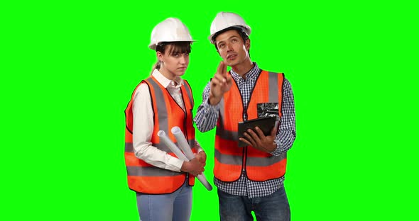 Front view of site workers using digital tablet with green screen