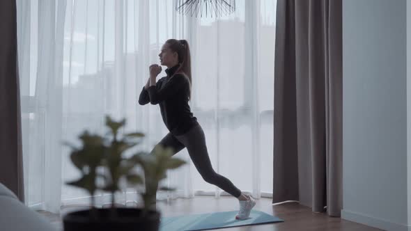 Young Woman Doing Squat Morning Exercise Alone in Living Room Training Workout at Home