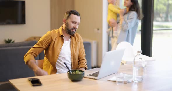 Father Works From Home with His Family