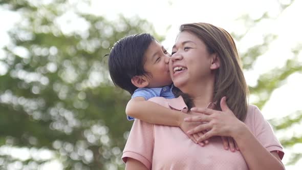 Asian Child On A Piggy Back Ride With Her Mother