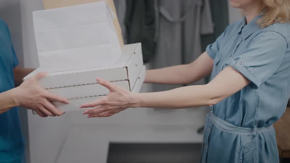 A Food Delivery Man Hands Over the Order to a Woman