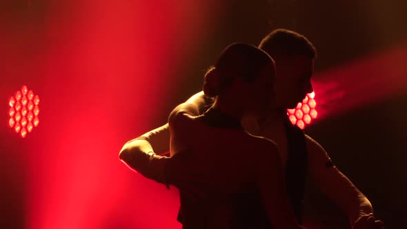 Graceful Argentine Tango Among Smoke and Bright Red Neon Lights in a Dark Studio