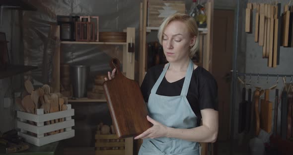 Portrait of Young Woman Carpenter Holding Handmade Wooden Cutting Board