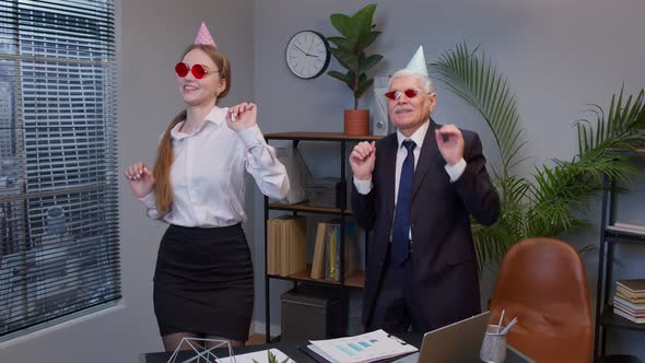 Smiling Secretary with Handsome Senior Businessman Company Director Dancing Victory Dance in Office