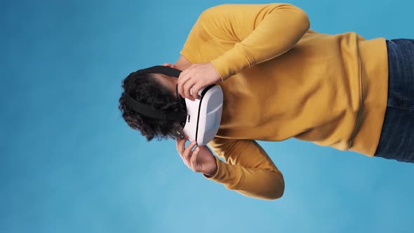 Man with VR headset enjoying experiencing virtual reality while standing on an isolated background