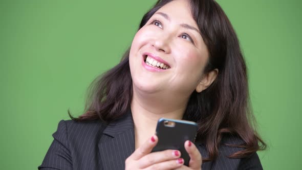 Mature Beautiful Asian Businesswoman Thinking While Using Phone