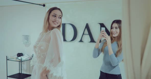 Beautiful Girl Makes a Fitting of an Elegant Wedding Dress in Front of a Mirror