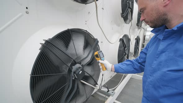 Technician uses a thermal imaging infrared thermometer to check the condensing