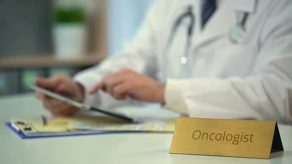 Oncologist Scrolling and Zooming Pages on Tablet PC, Consulting Patient Online