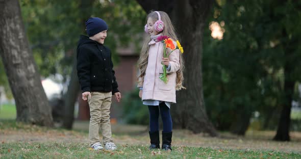 Two Children Stand and Laugh in the Park