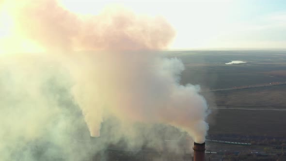 Industrial Zone with a Large Red and White Pipe Thick White Smoke Is Poured From the Factory Pipe