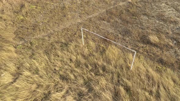 Abandoned soccer goal in the field 4K aerial footage