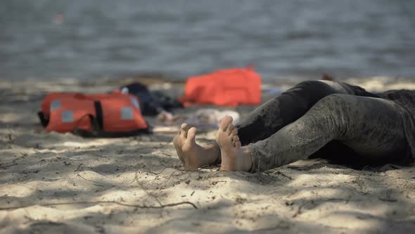 Muddy Female Legs Crawling on Shore, Life Jackets on Background, Surviving Storm