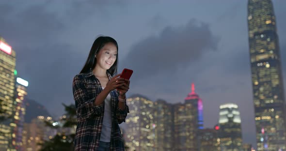 Woman check on mobile phone at outdoor in city at night