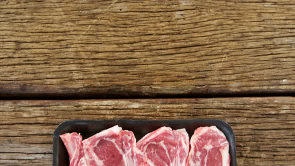 Sirloin steak in black container on wooden background