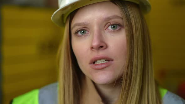 Headshot Annoyed Female Employee in Hard Hat Looking at Camera with Unsatisfied Facial Expression