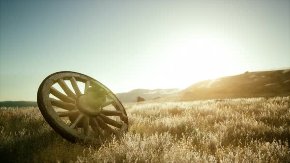 Old Wooden Wheel on the Hill at Sunset