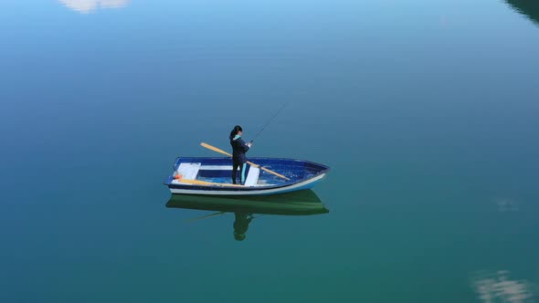 Woman on the Boat Catches a Fish on Spinning in Norway